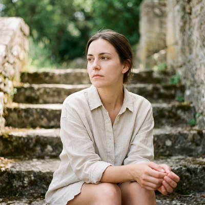 A person in a linen shirt sitting on stone steps